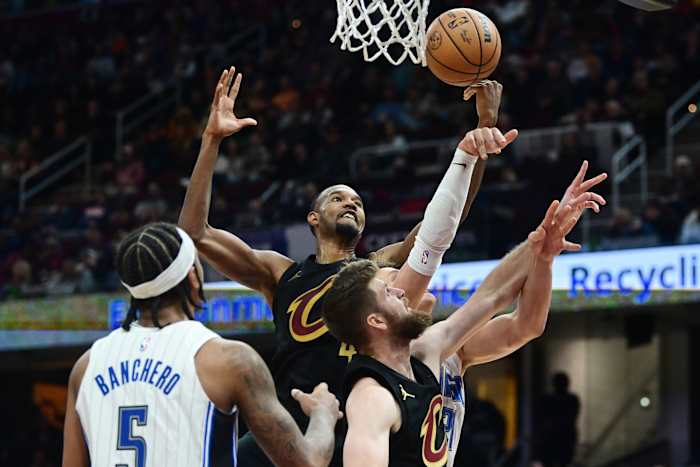 Dec 6, 2023; Cleveland, Ohio, USA; Cleveland Cavaliers forward Evan Mobley (4) and forward Dean Wade (32) go for a rebound against Orlando Magic center Moritz Wagner (21) and forward Paolo Banchero (5) during the second half at Rocket Mortgage FieldHouse.